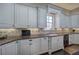 Well-lit kitchen showcasing granite countertops, ample cabinet space, stylish backsplash, and a stainless steel sink at 2160 Kensington Gates Nw Dr, Kennesaw, GA 30152