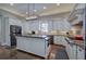 Modern kitchen featuring stainless appliances, a large island with granite countertops, and custom white cabinets at 2160 Kensington Gates Nw Dr, Kennesaw, GA 30152
