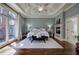 Serene main bedroom featuring tray ceilings, a fireplace, hardwood floors, and plenty of natural light at 2160 Kensington Gates Nw Dr, Kennesaw, GA 30152