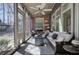 Bright sunroom with ample seating, brick accent wall, and backyard view at 2160 Kensington Gates Nw Dr, Kennesaw, GA 30152