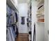 Narrow walk-in closet with hardwood floors and custom shelving and storage at 2160 Kensington Gates Nw Dr, Kennesaw, GA 30152