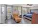 This bedroom features two large windows, a chair with ottoman, and a queen-sized bed with a tufted headboard at 261 Venture Path, Hiram, GA 30141