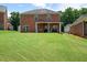 Expansive backyard featuring lush green lawn and covered patio area, perfect for outdoor enjoyment at 1147 Scenic Park Trl, Lawrenceville, GA 30046
