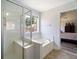 Bright bathroom featuring walk-in shower and soaking tub with a view of the neighborhood at 1147 Scenic Park Trl, Lawrenceville, GA 30046