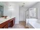 Bathroom with double sinks, a vanity, walk-in shower, and soaking tub at 1147 Scenic Park Trl, Lawrenceville, GA 30046