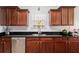 A close-up view of the kitchen with dark wood cabinets, black countertops, and stainless steel sink at 1147 Scenic Park Trl, Lawrenceville, GA 30046