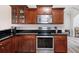 Kitchen features wood cabinets, stainless steel appliances, black countertops, and light-colored floors at 1147 Scenic Park Trl, Lawrenceville, GA 30046