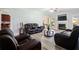 Living room with hardwood floors, fireplace, ceiling fan, and comfortable brown leather sofas and chairs at 1147 Scenic Park Trl, Lawrenceville, GA 30046