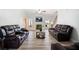 Bright living room with hardwood floors, fireplace, ceiling fan, and comfortable brown leather sofas at 1147 Scenic Park Trl, Lawrenceville, GA 30046