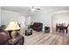 Open concept living room showing the dining room, leather couches, and wood-look floors at 1147 Scenic Park Trl, Lawrenceville, GA 30046