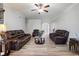 Open-concept living room with wood-look flooring, leather seating, and a ceiling fan at 1147 Scenic Park Trl, Lawrenceville, GA 30046