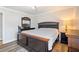 Main bedroom with hardwood floors, neutral walls, and dark wood furniture, with a bedside lamp at 1147 Scenic Park Trl, Lawrenceville, GA 30046