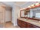 Bright bathroom featuring double vanity, granite counters, cherry wood cabinets, and large mirror at 260 W Peachtree St, Norcross, GA 30071