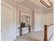 Hallway with neutral carpet and decorative artwork on the wall, along with a table and vases at 260 W Peachtree St, Norcross, GA 30071