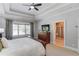 Well-lit main bedroom with neutral walls, tray ceilings, carpeted floors, and an attached bathroom at 260 W Peachtree St, Norcross, GA 30071