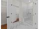 Modern bathroom with marble floors and an all glass walk in shower with bench seating at 3209 Telhurst Way, Buford, GA 30519
