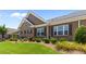 Well-manicured lawn featuring a beautifully landscaped brick home with a side patio at 3209 Telhurst Way, Buford, GA 30519