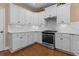 Bright kitchen with white cabinets, hardwood floors, and stainless steel appliances at 3209 Telhurst Way, Buford, GA 30519