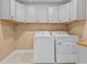 Utility area featuring white washer and dryer units and custom white upper cabinets at 3209 Telhurst Way, Buford, GA 30519