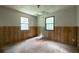 Bedroom featuring wood paneling and two windows allowing natural light at 400 Mccart Rd, Mcdonough, GA 30252