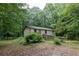 Exterior view of a quaint home surrounded by lush trees and greenery, offering privacy at 400 Mccart Rd, Mcdonough, GA 30252