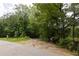 Roadside view of a wooded lot featuring an entrance with signage and lush trees at 400 Mccart Rd, Mcdonough, GA 30252