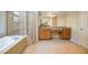 Well-appointed bathroom with a soaking tub, separate glass shower, vanity, and tiled floors at 115 Dunlavin Dr, Acworth, GA 30102