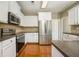 Beautiful kitchen with stainless steel appliances, white cabinets, granite countertops, and hardwood flooring at 115 Dunlavin Dr, Acworth, GA 30102