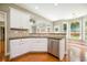 Open kitchen with white cabinetry, stainless appliances, and views into the living and dining areas at 115 Dunlavin Dr, Acworth, GA 30102