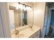 Bright bathroom featuring double sinks, a large mirror, and a shower-tub combination at 1200 Martins Chapel Se Ln, Lawrenceville, GA 30045