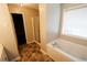 Bathroom with a tub, window, and glass-enclosed shower, plus tiled floors at 1200 Martins Chapel Se Ln, Lawrenceville, GA 30045
