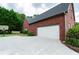 View of the side exterior showing a large garage, basketball hoop and a well-maintained yard at 1200 Martins Chapel Se Ln, Lawrenceville, GA 30045