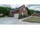 View of the side exterior showing a large garage, basketball hoop and a well-maintained yard at 1200 Martins Chapel Se Ln, Lawrenceville, GA 30045