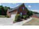 View of the side exterior showing a large garage, basketball hoop and a well-maintained yard at 1200 Martins Chapel Se Ln, Lawrenceville, GA 30045