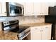 Kitchen features granite countertops, stainless steel appliances, and white cabinetry at 1200 Martins Chapel Se Ln, Lawrenceville, GA 30045