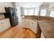 View of kitchen showing granite counters, stainless steel appliances, and wood floor at 1200 Martins Chapel Se Ln, Lawrenceville, GA 30045