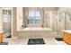Luxurious bathroom featuring a tub and a glass enclosed shower with bright sunny windows at 1209 Persimmon Way, Mcdonough, GA 30252
