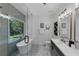 Bright bathroom featuring a soaking tub under a window, a glass-enclosed shower, and a vanity with modern fixtures at 3021 Stone Bridge Sw Trl, Conyers, GA 30094