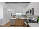 Contemporary kitchen with white and wood cabinetry, patterned backsplash, and stainless steel appliances at 3021 Stone Bridge Sw Trl, Conyers, GA 30094