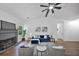 Bright living room boasts a fireplace, a modern fan, and hardwood floors at 3021 Stone Bridge Sw Trl, Conyers, GA 30094