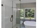 A luxurious glass enclosed walk-in shower featuring elegant fixtures and tile work at 3021 Stone Bridge Sw Trl, Conyers, GA 30094