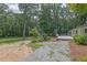 Large backyard with a stone path leading to a wooden deck, surrounded by mature trees and lush greenery at 2546 N Crestview Dr, Grayson, GA 30017
