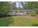 Exterior view of a backyard and deck with a brick home and lush landscaping at 2546 N Crestview Dr, Grayson, GA 30017