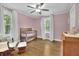 Charming Bedroom with a wooden crib, rocking chair, changing table, and large windows at 2546 N Crestview Dr, Grayson, GA 30017