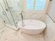 Elegant bathroom with a soaking tub and glass enclosed shower at 3871 Portland Trail Dr, Suwanee, GA 30024