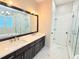 Modern bathroom featuring double vanity, dark wood cabinets and a large mirror at 3871 Portland Trail Dr, Suwanee, GA 30024