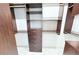 Walk-in closet with dark wood organizers and ample shelving at 3871 Portland Trail Dr, Suwanee, GA 30024