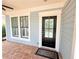 View of the front entrance with black front door, brick porch and white trim at 3871 Portland Trail Dr, Suwanee, GA 30024