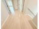 Bright hallway with light hardwood floors and neutral walls, showcasing a clean and open transition between spaces at 3871 Portland Trail Dr, Suwanee, GA 30024