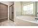 Bright bathroom with large tub, a window view, a walk-in closet and a glass shower at 6005 Crowley Dr, Douglasville, GA 30135